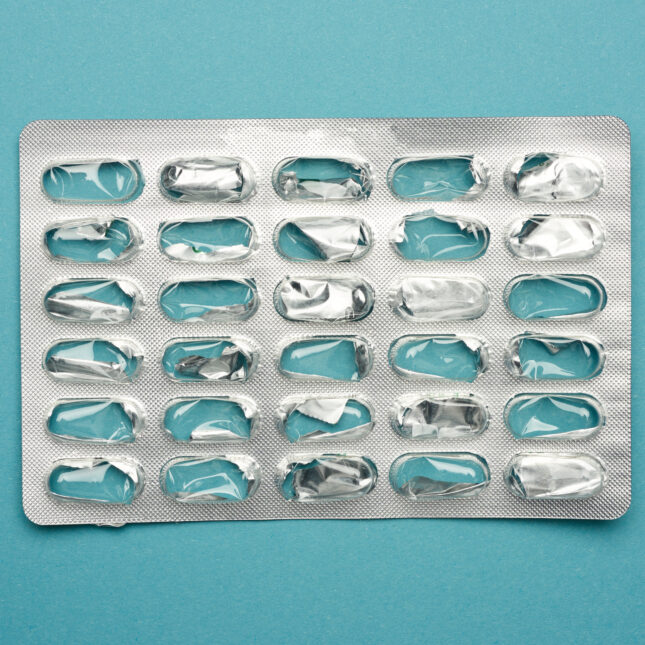 Photo of an empty pill blister package against a blue backdrop. -- health coverage from STAT