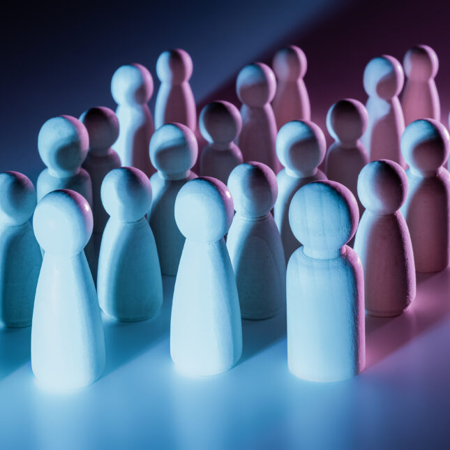 An army of wooden figures under blue and pink lighting — biotech coverage from STAT