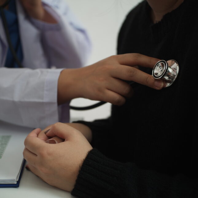 A doctor uses stethoscope on a patient — health coverage from STAT