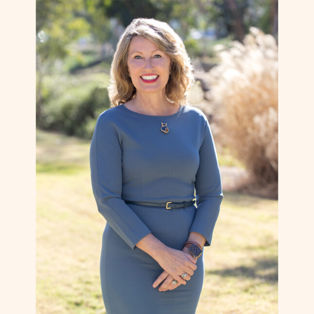 Cat Jamieson, a white woman with short blonde hair, smiles at the camera wearing a greyish blue dress — first opinion coverage from STAT