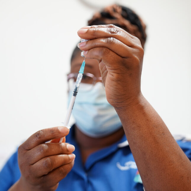 A nurse prepares a does of the spring Covid-19 booster shot