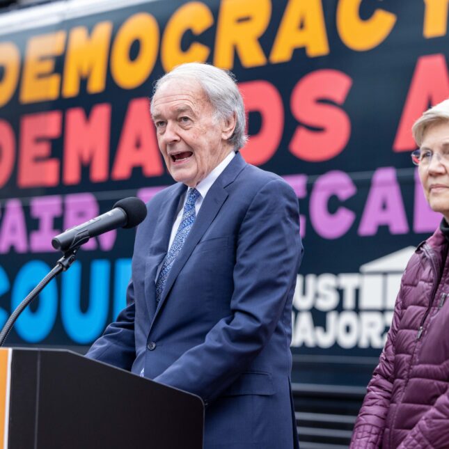 Sen. Ed Markey speaks to a microphone at a podium as Sen. Elizabeth Warren stands next to him during the "Just Majority" Supreme Court Accountability Campaign Launch Press Conference — coverage from STAT