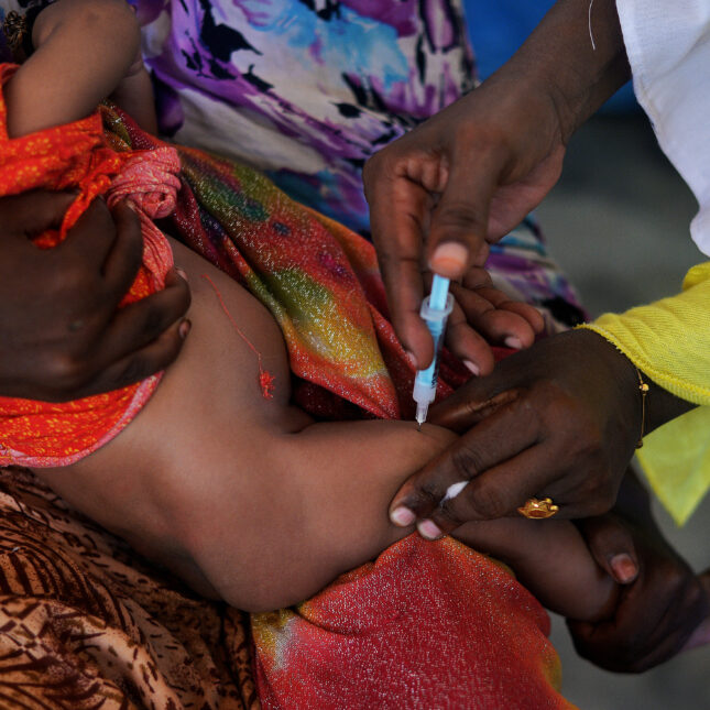 A Somali baby receives a pentavalent vaccine while being held by an adult — first opinion coverage from STAT