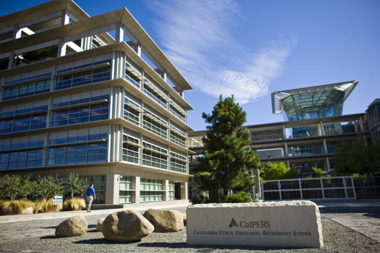 The text "CalPERS" and "California Public Employeesâ Retirement System" engraved on a stone sign in front of an L-shaped glass building â business coverage from STAT