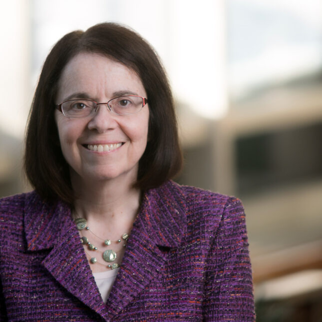 Anne Klibanski, a white woman with short hair, smiles in a purple blazer and glasses — coverage from STAT